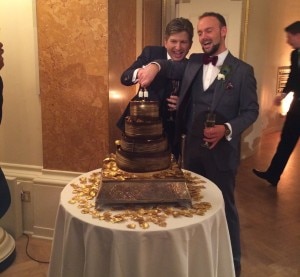 Two men cutting the cake at their wedding