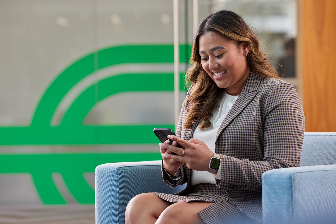 Woman seated looking at smartphone